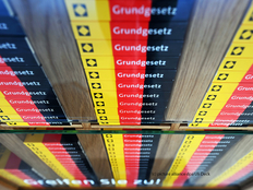 Ansicht der Buchrücken des schwarz-rot-goldenen Grundgesetzes, gestapelt