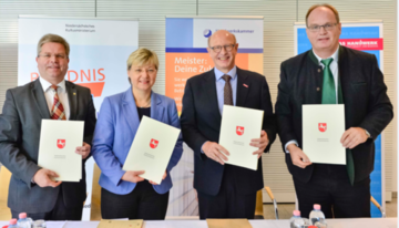 Unterzeichner mit Urkunde in der Hand