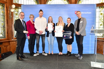 Schülerinnen und Schüler der Carl-Hahn-Schule mit Lehrer und Kultusminister Tonne und Urkunde auf der Bühne