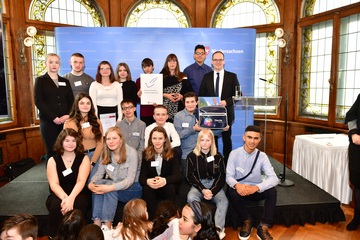 Schülerinnen und Schüler der IGS Badenstedt mit Kultusminister Tonne und Urkunde auf der Bühne