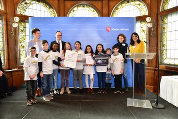 Schülerinnen und Schüler der Regenbogenschule Seelze mit Lehrerinnnen und Kultusminister auf der Bühne