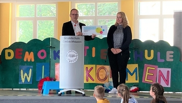 Kultusminister Grant Hendrik Tonne zeichnet die Grundschule Eimbeckhausen aus und überreicht Schulleiterin Diana Rosenthal unter anderem ein repräsentatives Schild