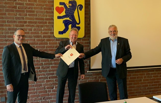 Fotot, drei Männer, Minister Tonne überreicht den Biwilligunhgsbescheid