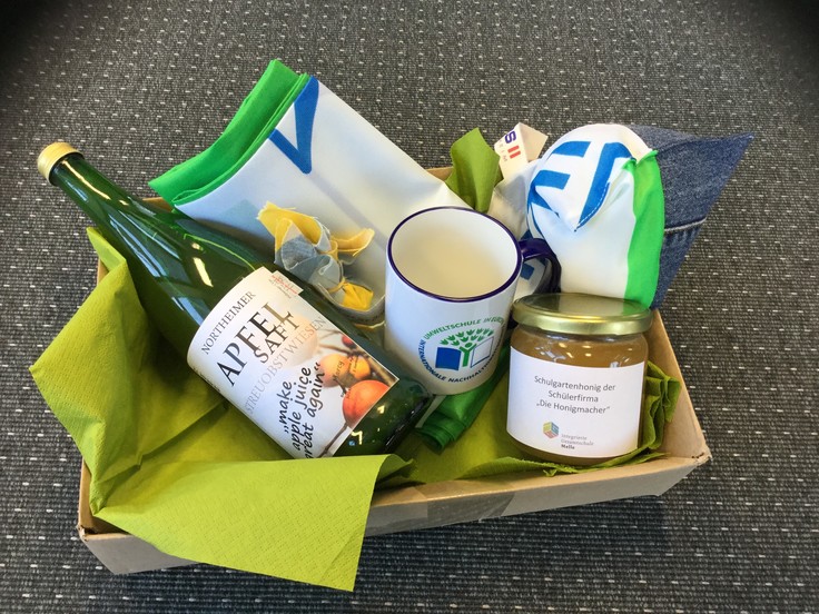 Foto mit Lebensmitteln und Gegenständen in einem Karton als Geschenk an den minister