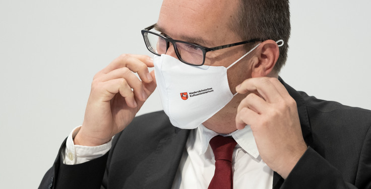 Ein Mann nimmt seine Schutzmaske vom gesicht ab