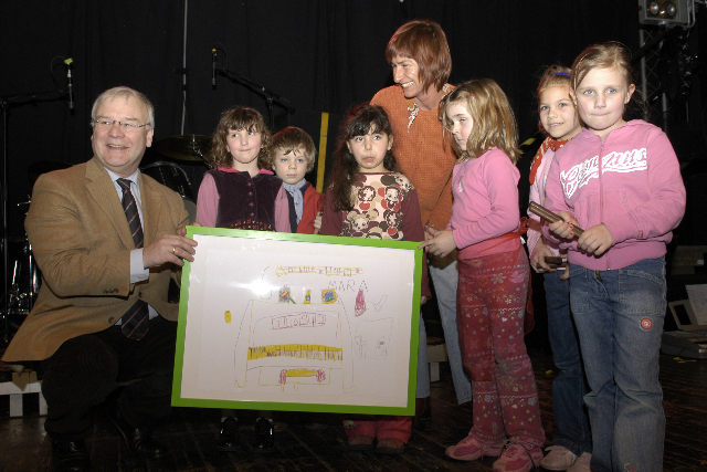 Minister Busemann mit kleinen Kindern und einem gemalten Bild