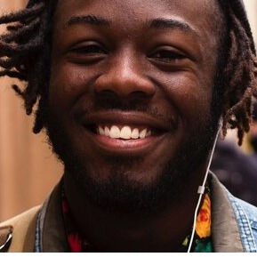 Portrait eines farbigen Jugendlichen, unscharfer Hontergrund mit Menschen auf der Straße